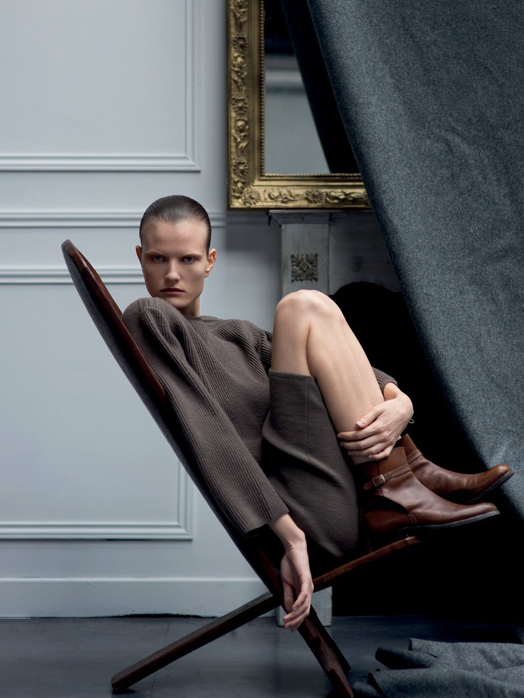 person sits in chair in front of fireplace