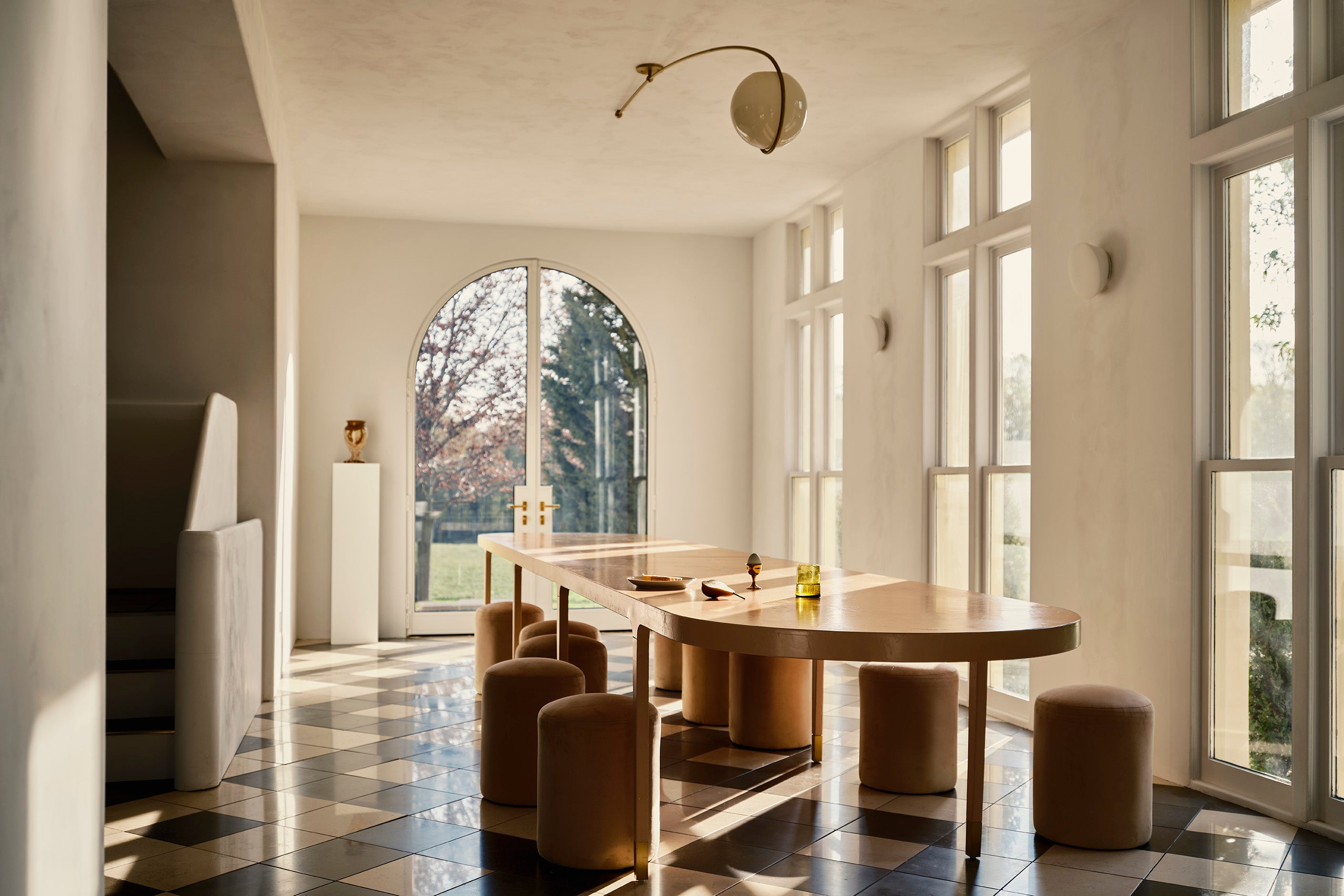 a long dining table in a bright dining room with large windows