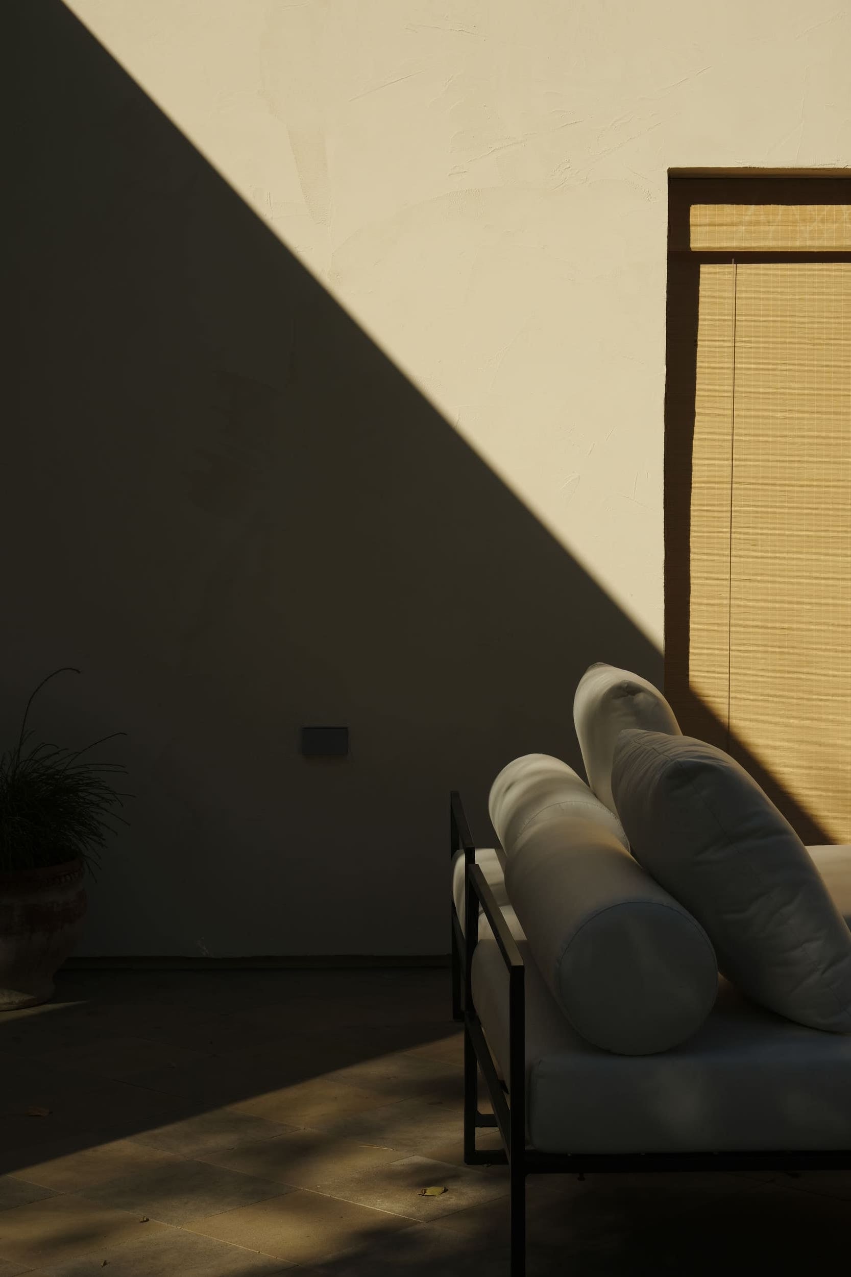 white patio furniture in shadow on the terrace