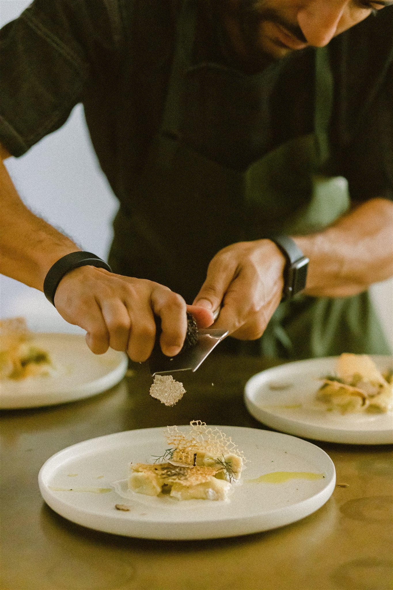 chef grates truffle onto a dish