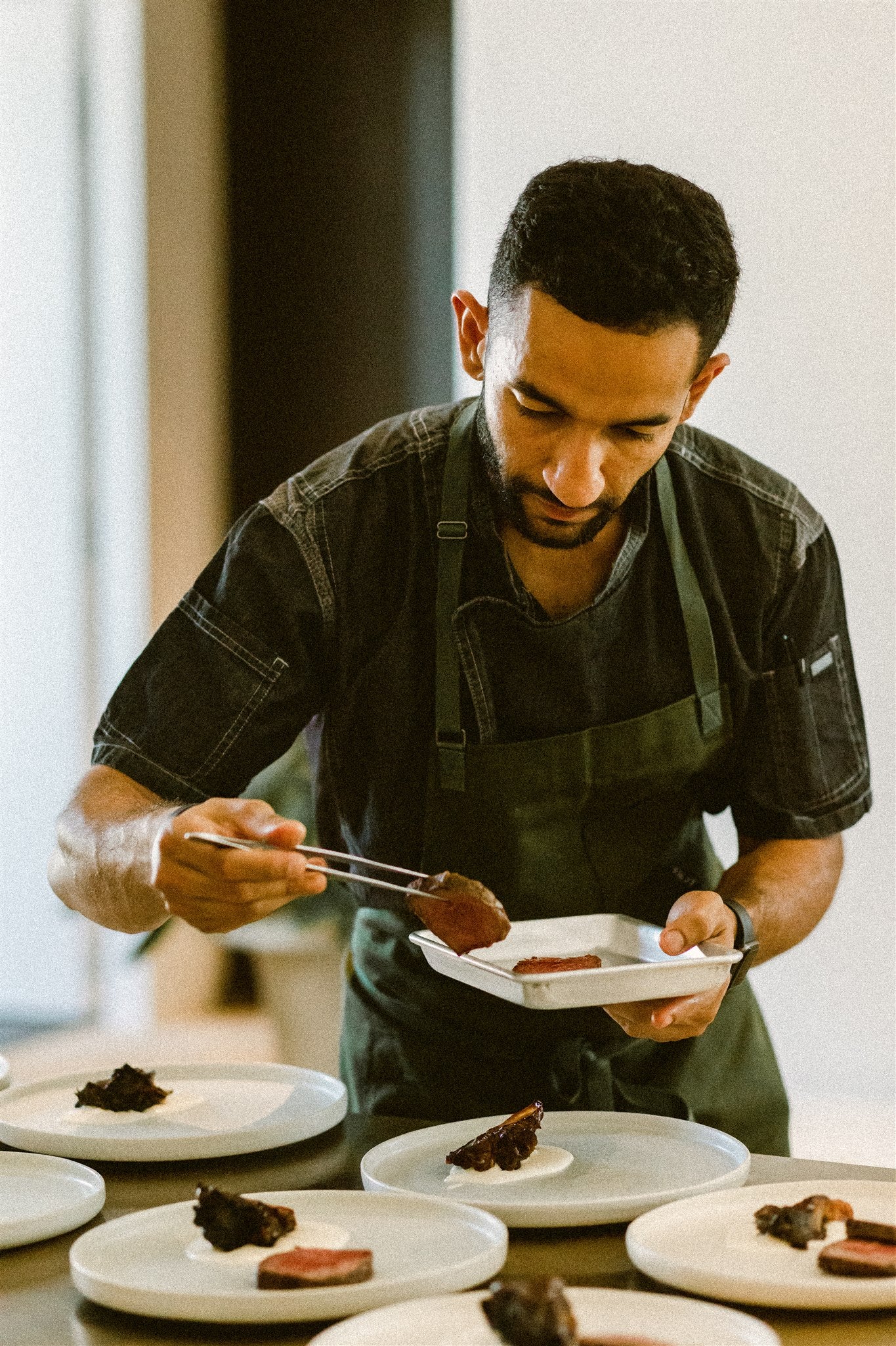 chef Aakash Dhall plating meat onto a series of plates