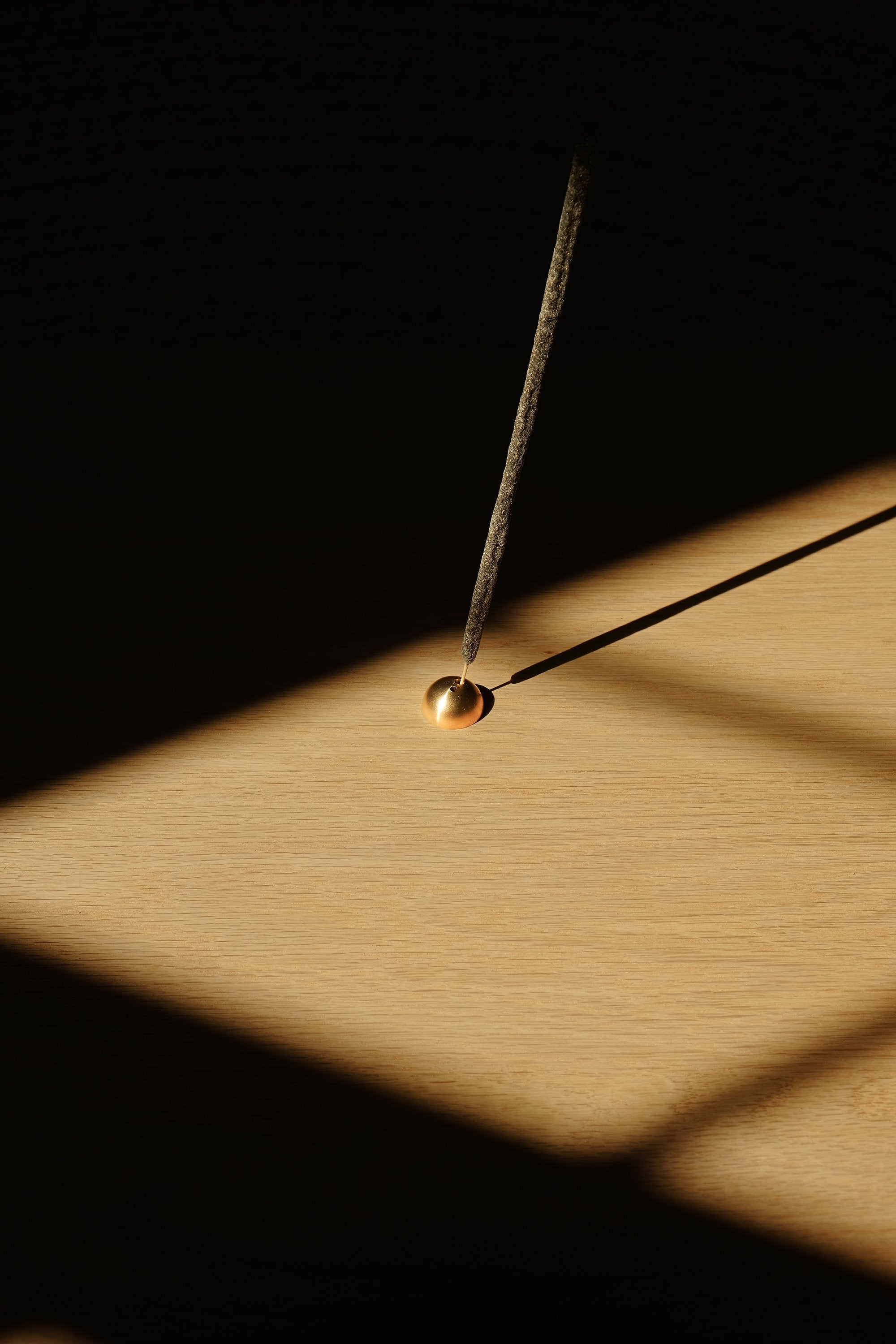 A minimalist half moon shape incense holder made of brass