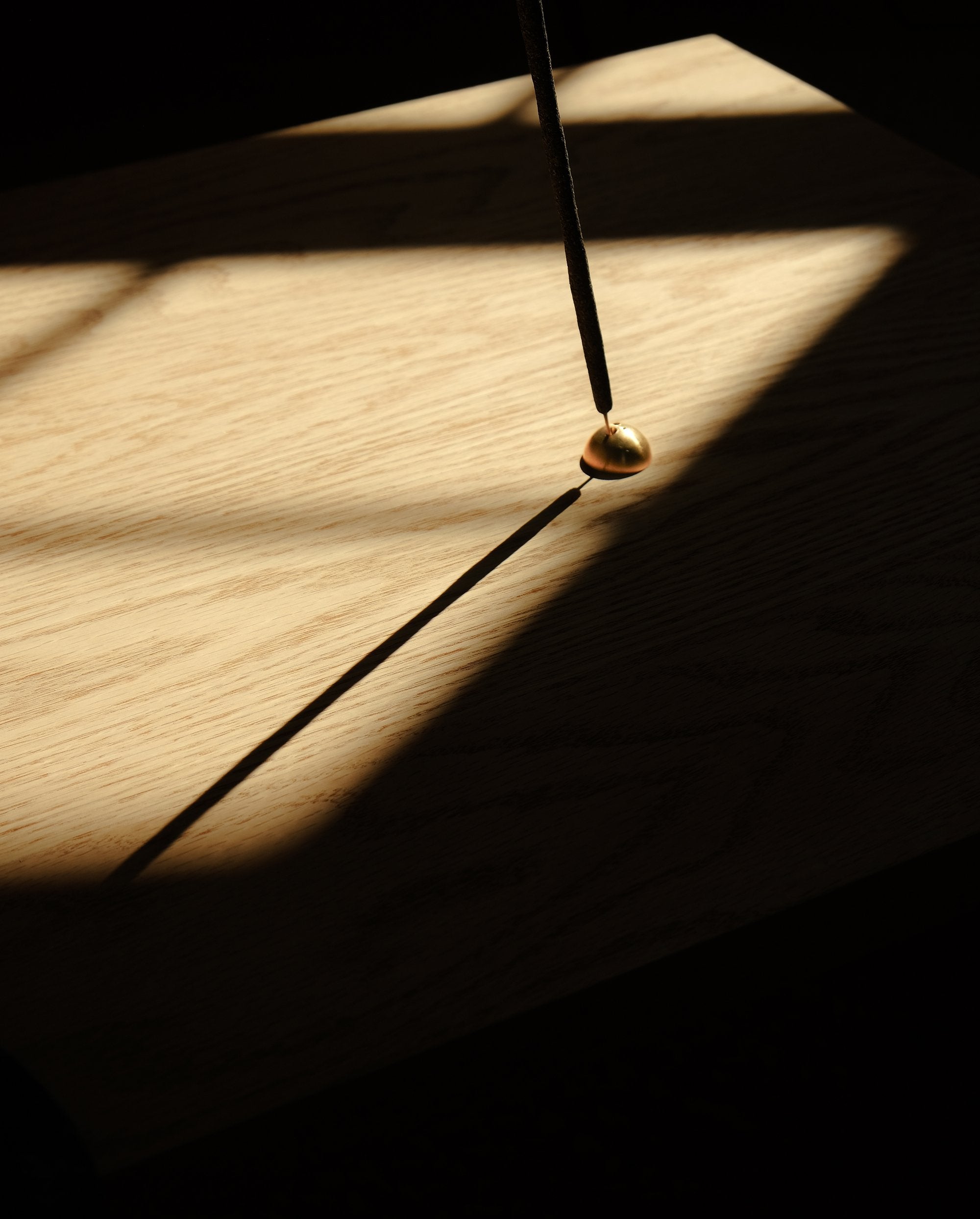 A minimalist half moon shape incense holder made of brass