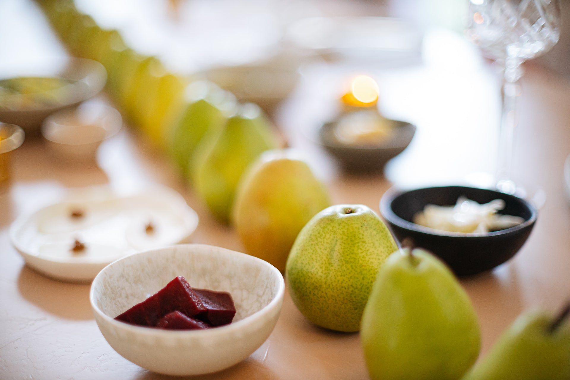 closeup of small bowls filled with food and a row of pears