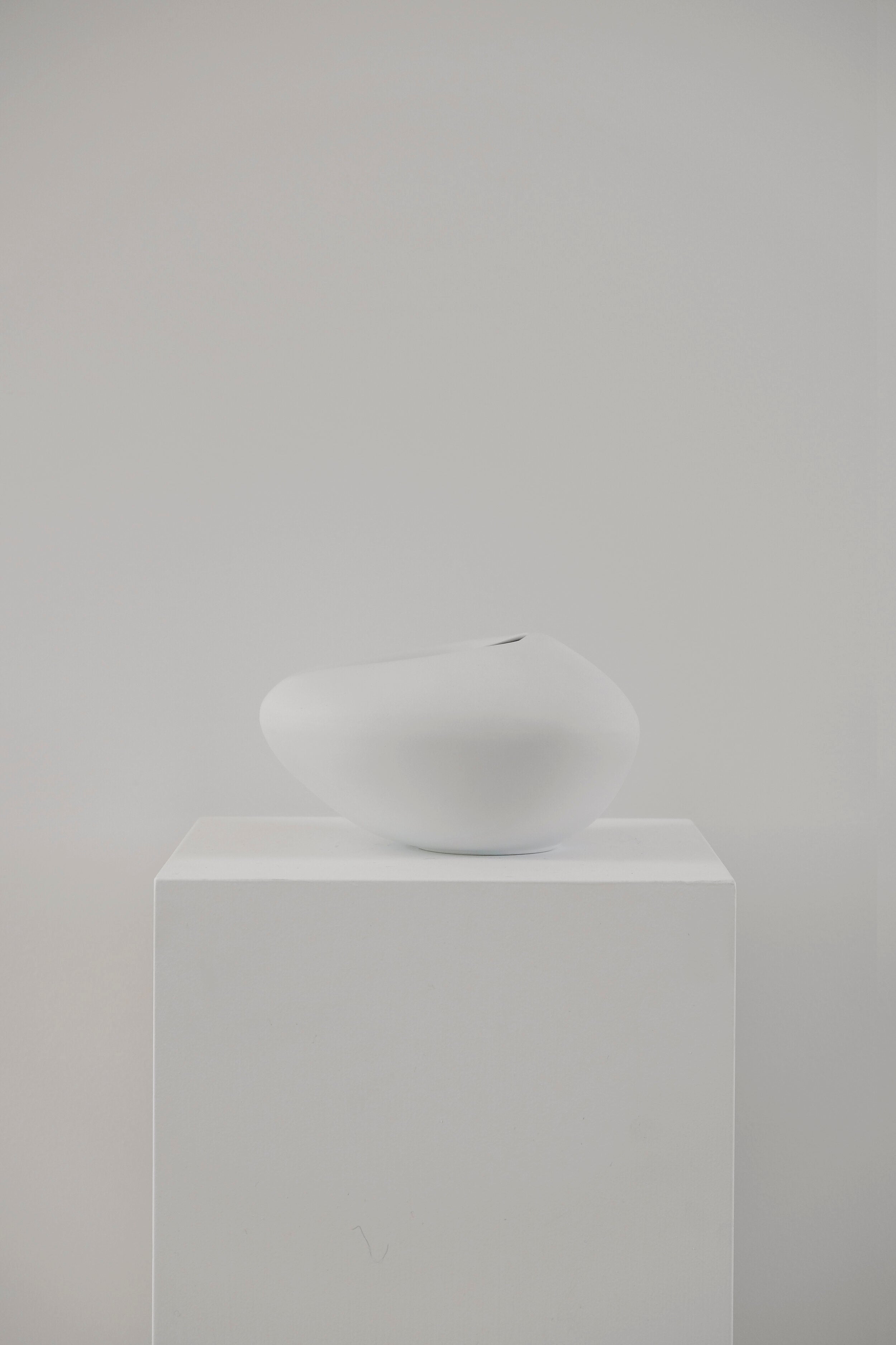 white vase on white plinth