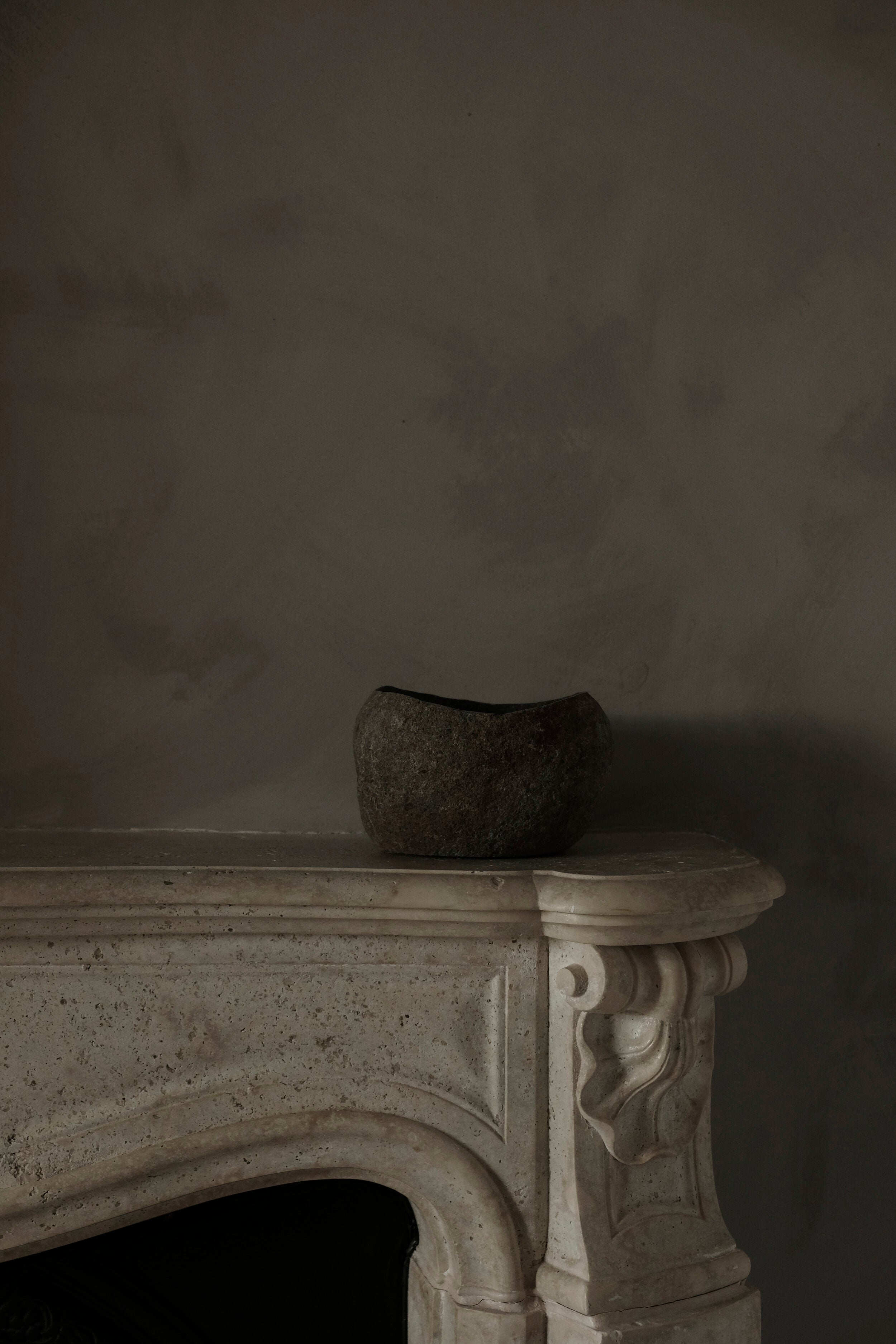 stone bowl on white marble fireplace mantle