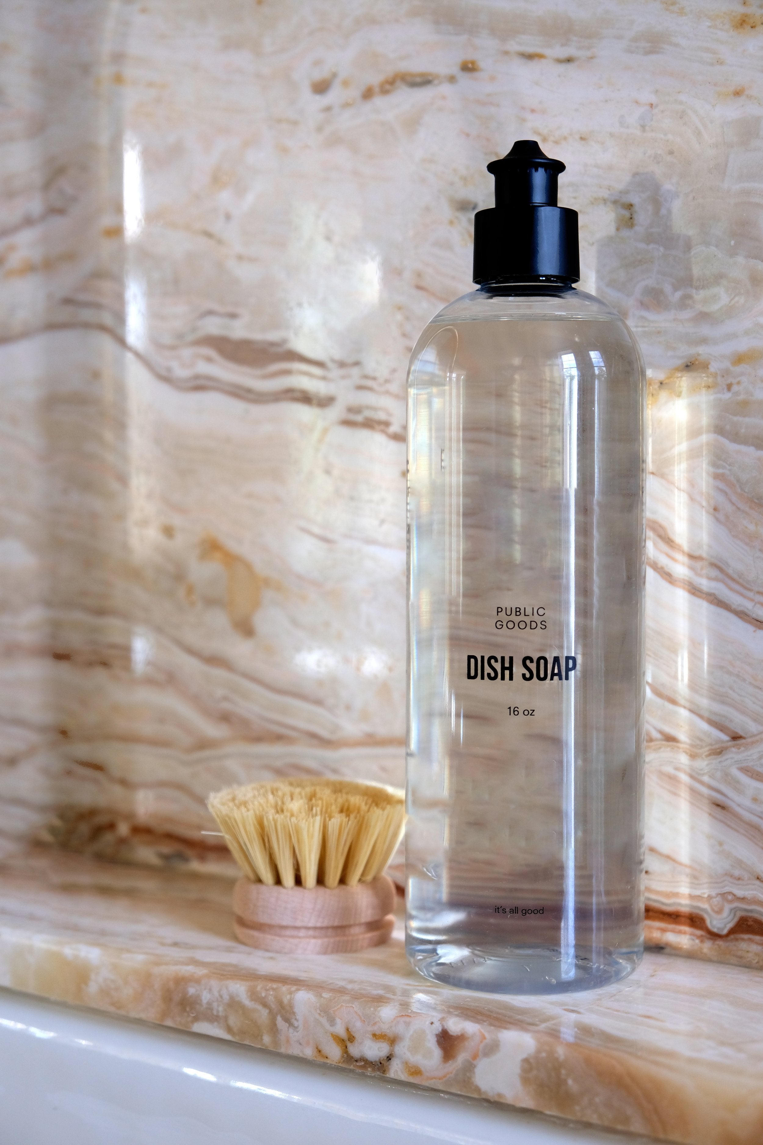 bottle of dish soap sits on the edge of a kitchen sink