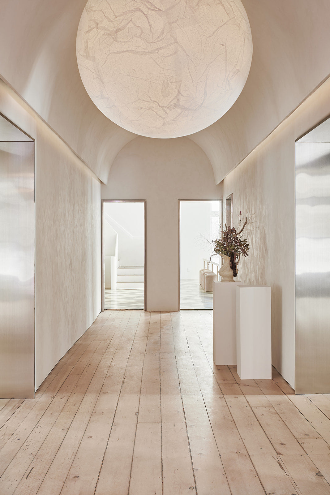 a large moon pendant hangs in a bright hallway