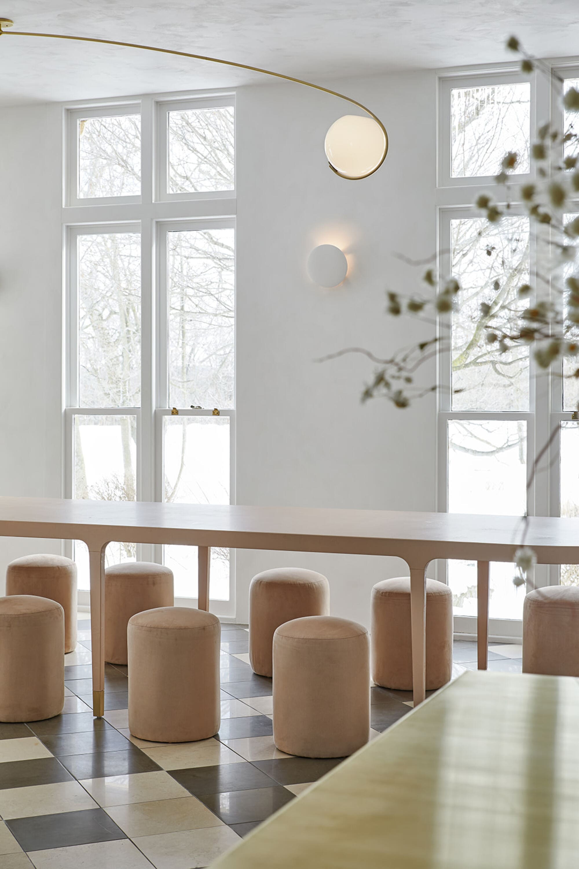 a long dining table in a bright dining room with large windows