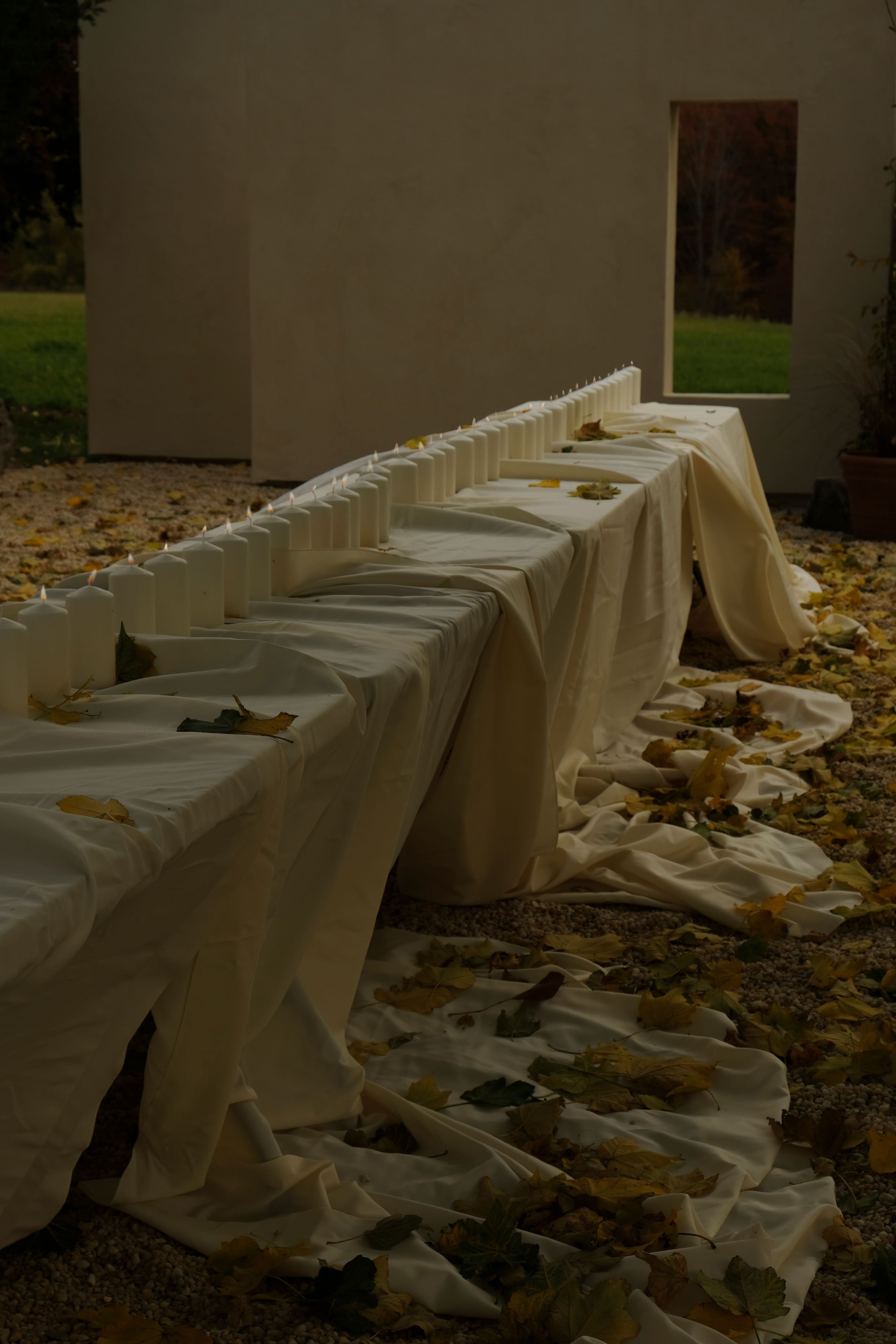 long table with a line of pillar candles down the middle, sitting outside on the terrace