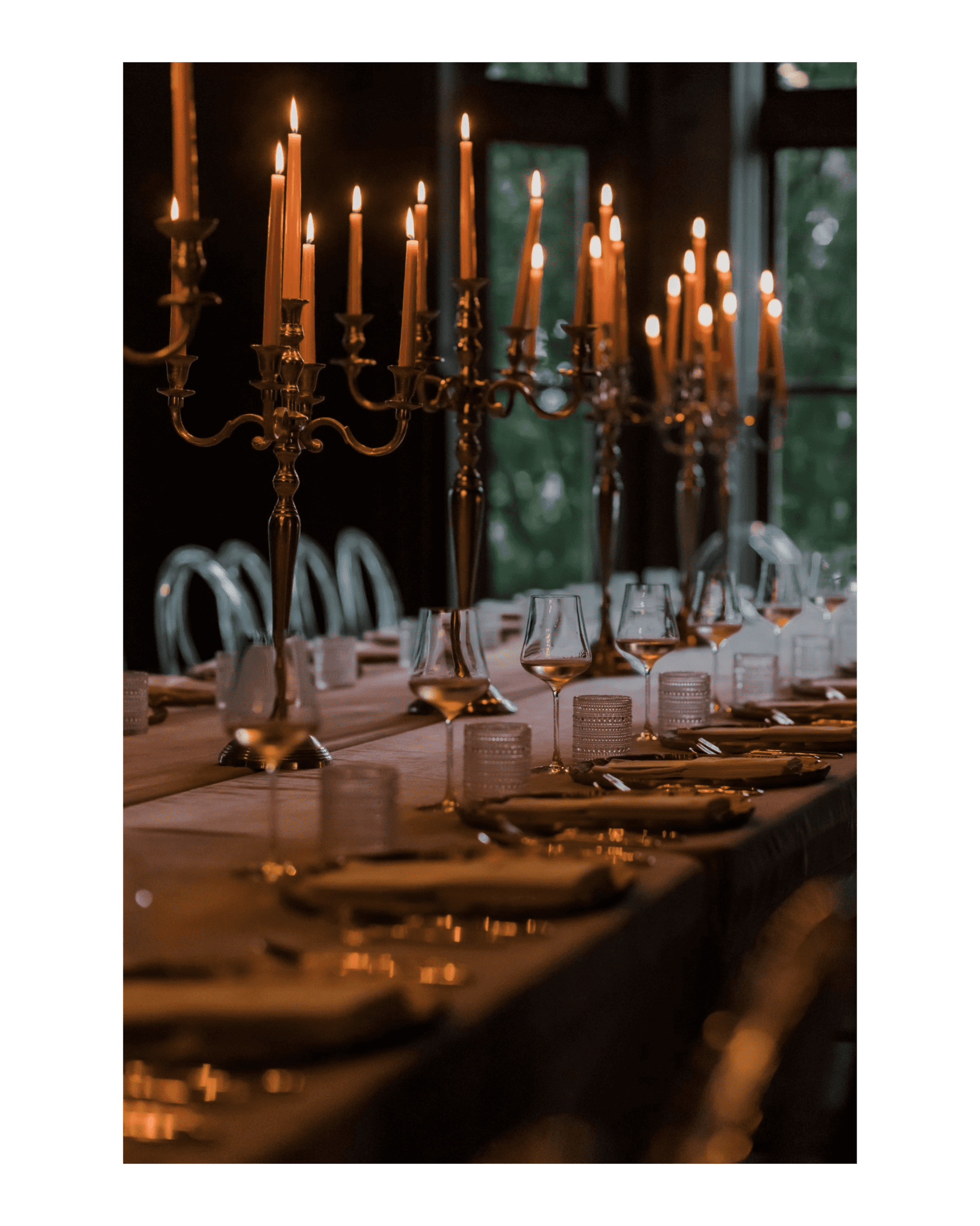 long table set with lit candelabras