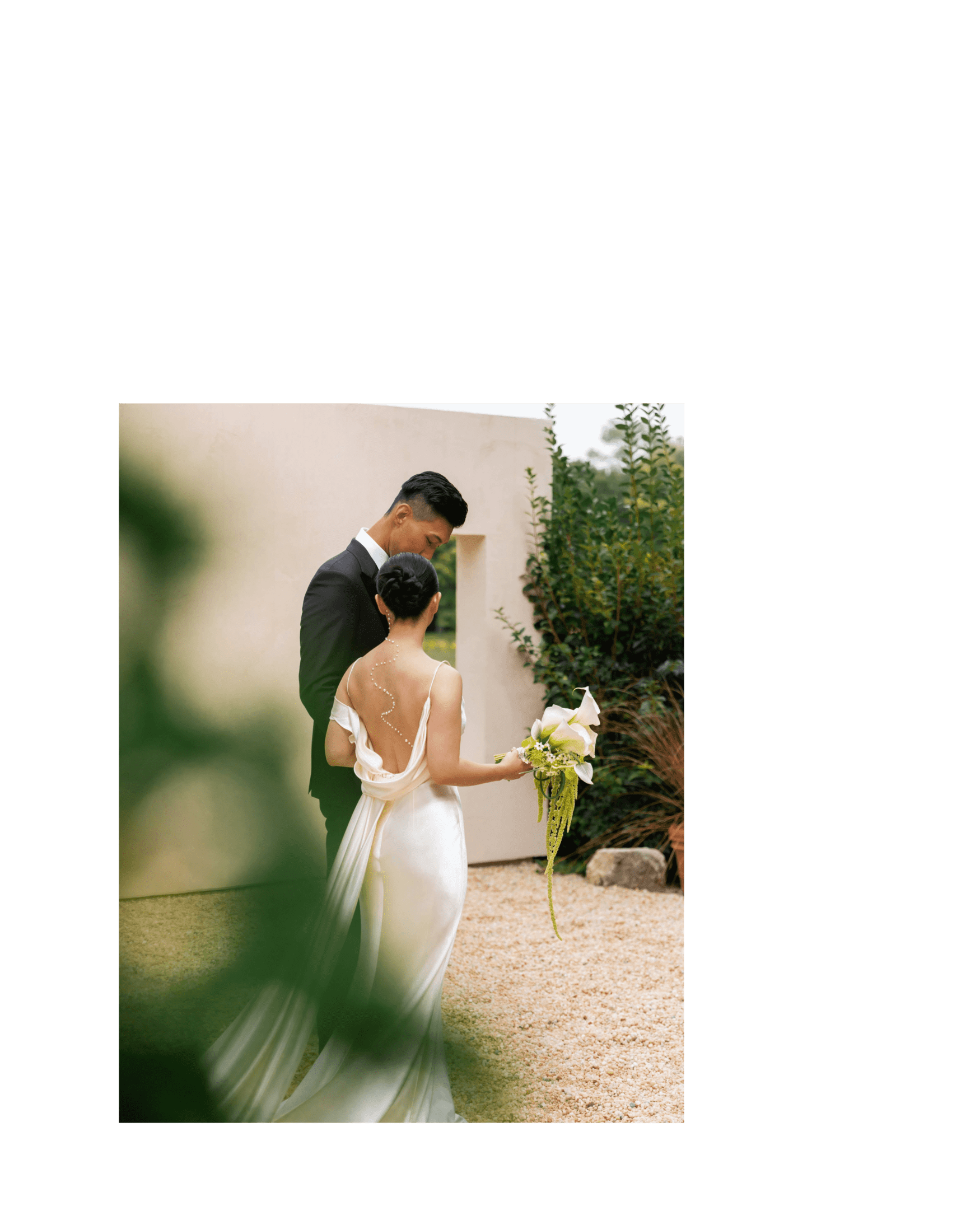 bride and groom in front of stucco walls on terrace