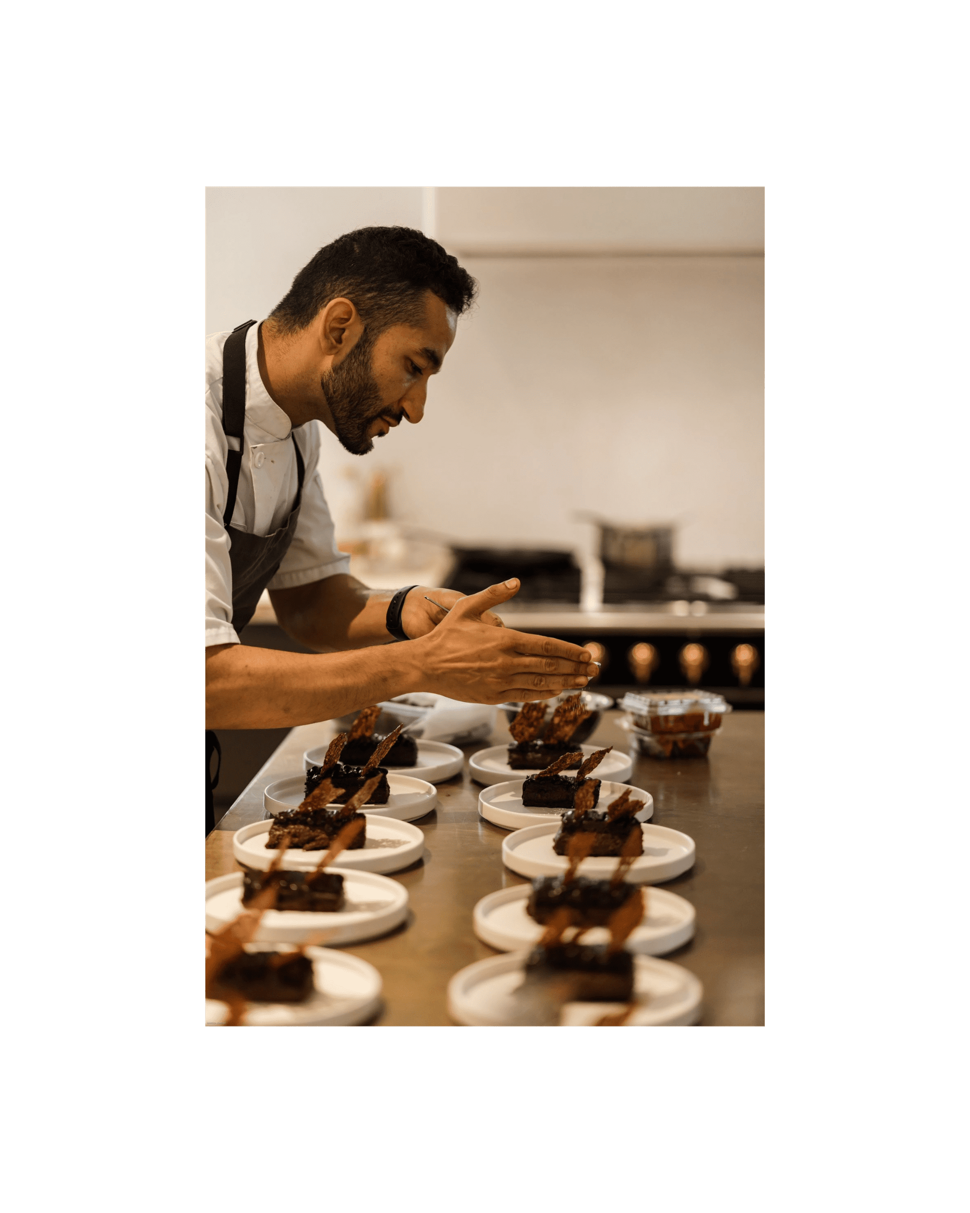 chef Aakash Dhall adds the finishing touches on a row of dishes